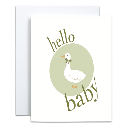 A square greeting card with a white envelope behind it. The card features a white duck with a green bow tie inside a pale green circle, with the words 'hello baby' in olive green script around it.