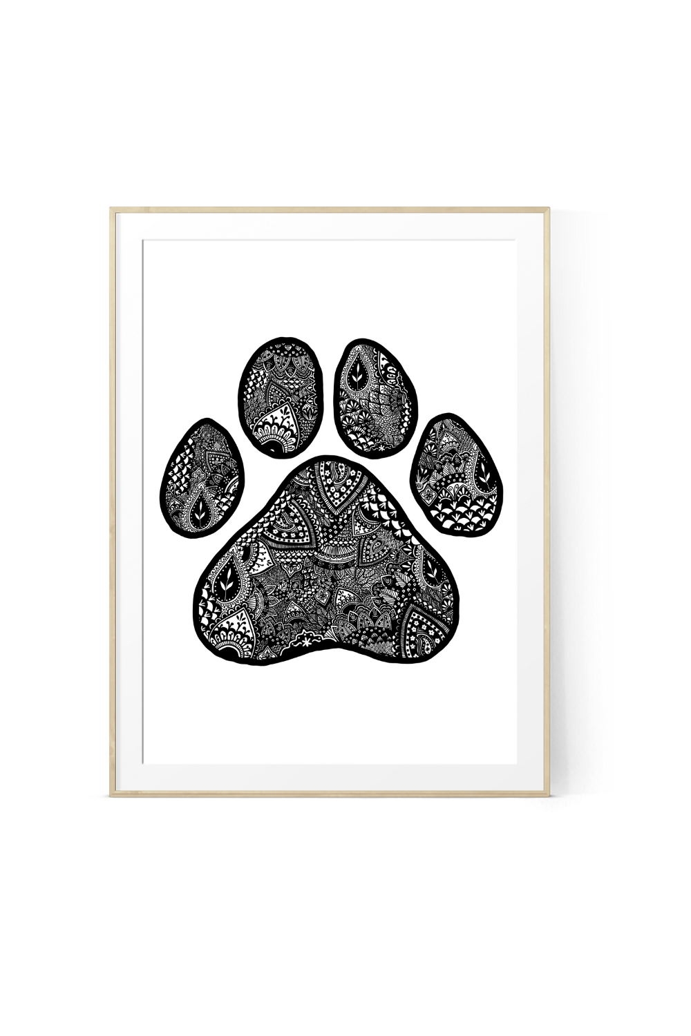 Detailed black and white art print of an animal paw print filled entirely with intricate mandala art, floral patterns, and geometric lines, framed in a light wood border.